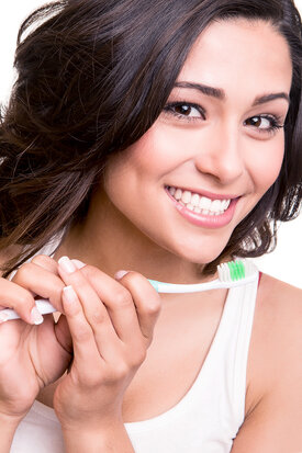 beautiful woman smiling holding toothbrush, cosmetic dentistry in Yakima, WA
